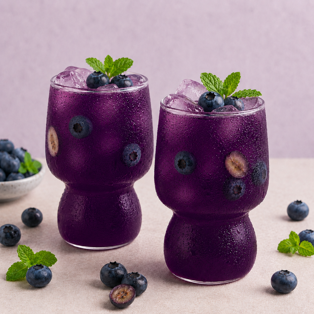 Glasses of AQUON Exotic Blueberry electrolyte hydration drink with fresh fresh blueberries